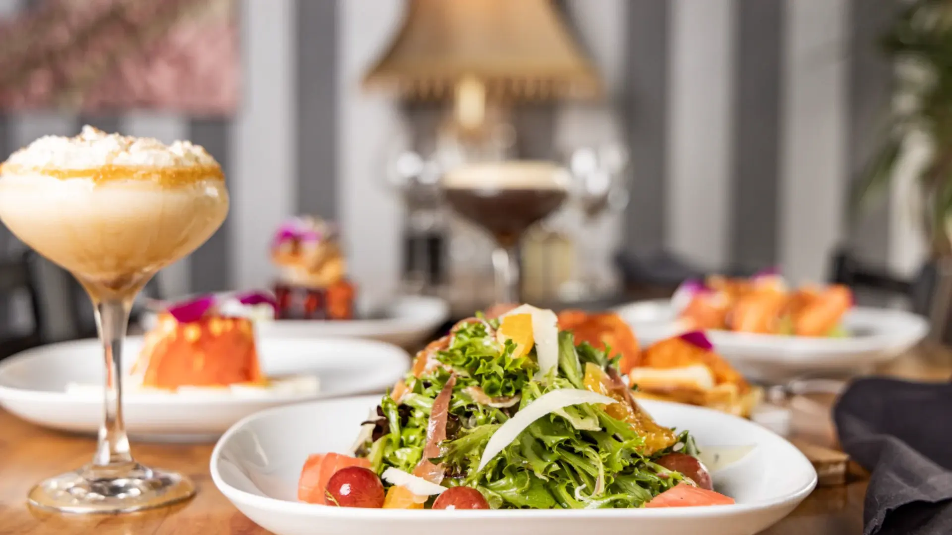 Fresh salad, cocktails, and tapas spread at The Manhattan