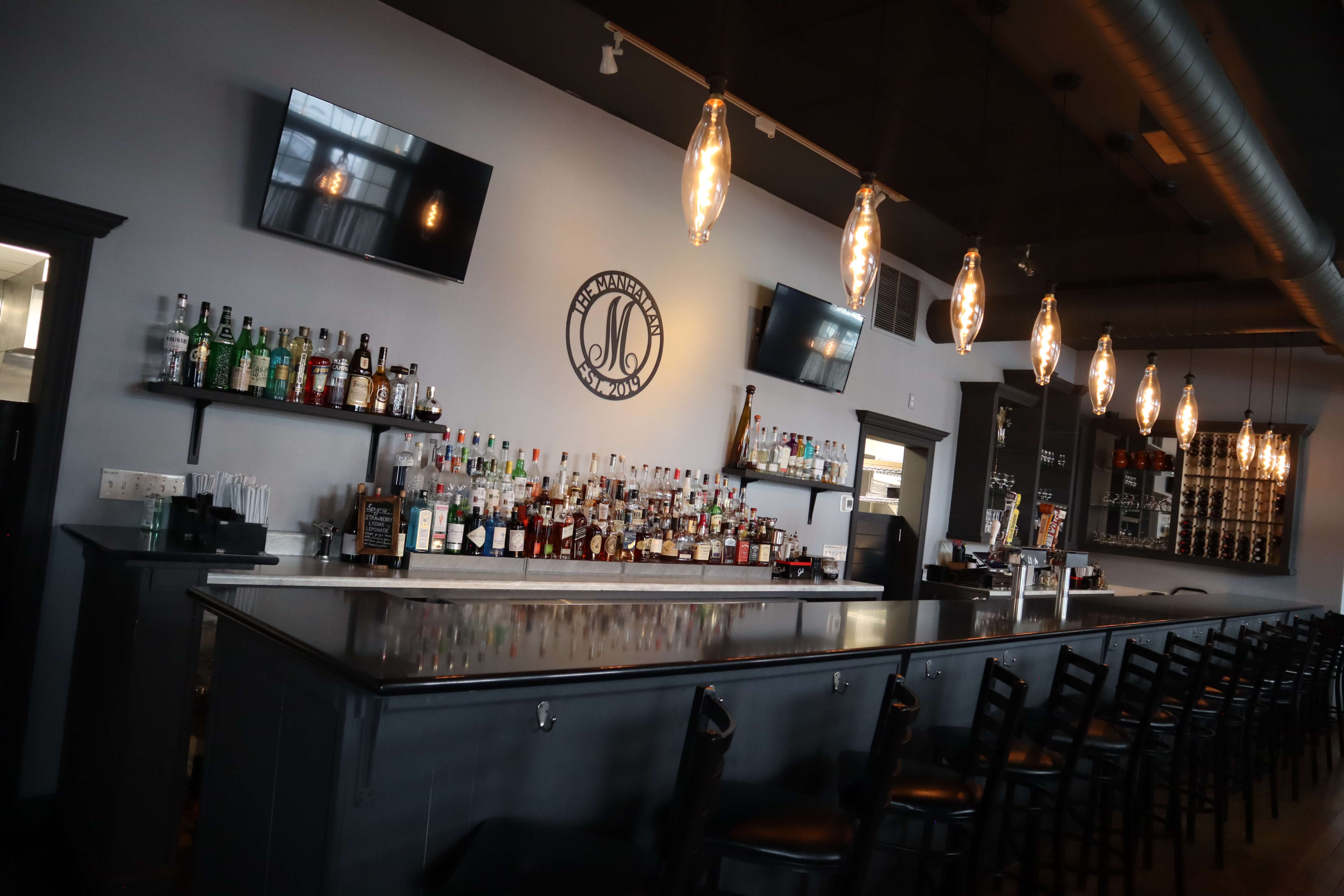The Manhattan bar with pendant lights and wine rack
